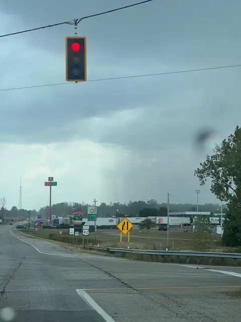 Red light, gray sky, and a shower in the distance.
